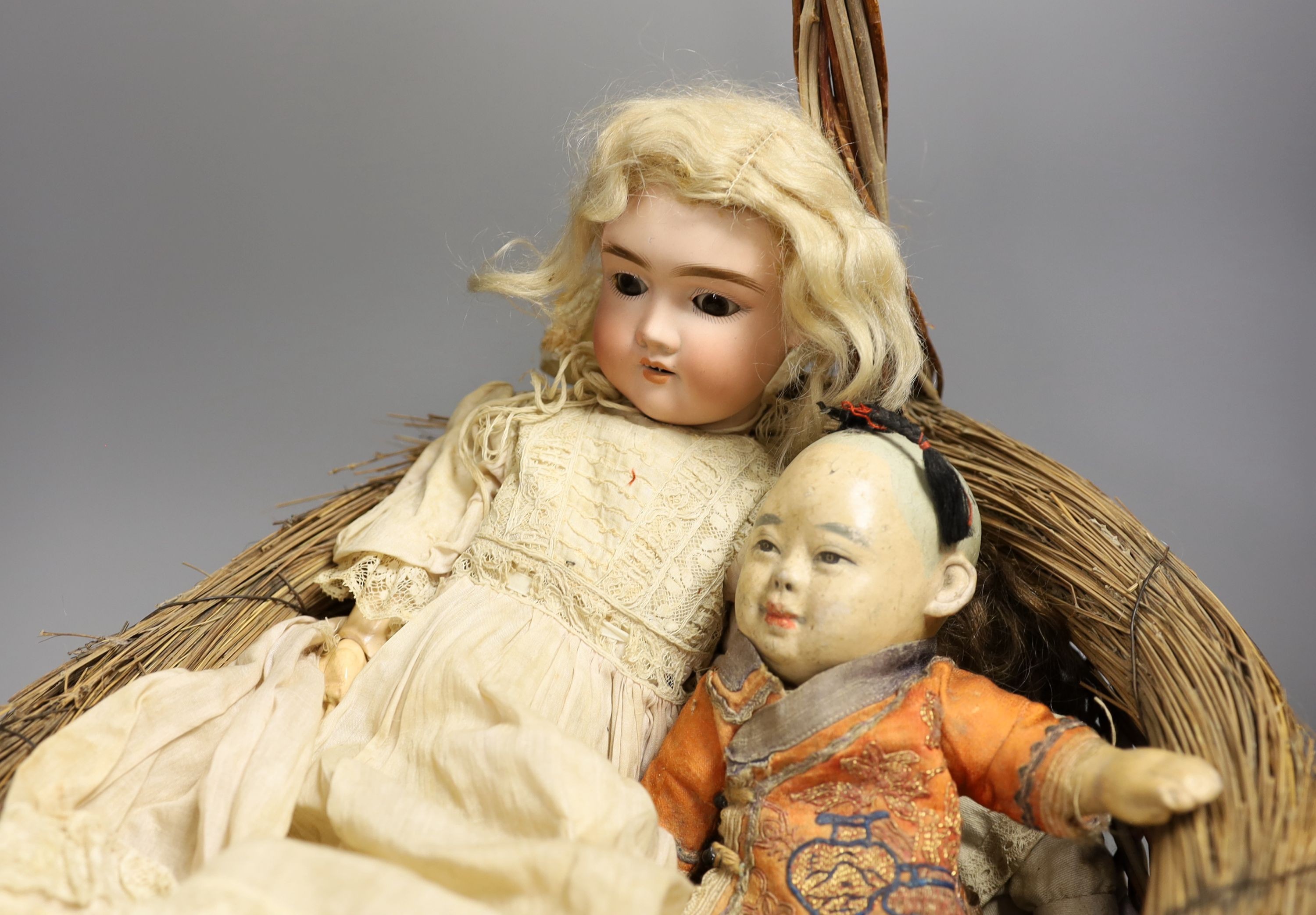 An early 20th century Max Handwerke bisque doll with open mouth and sleeping eyes, H 46 cms, one other smaller German bisque doll, a composition Chinese baby doll and nine others, some miniature and incomplete.